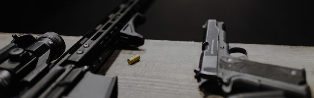 Rifle and handgun on shooting bench